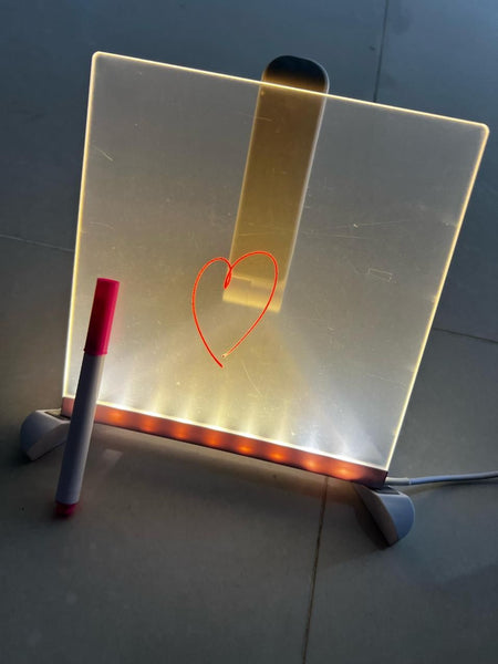 3D LED writing pad illuminated with a heart drawing and a pink marker beside it