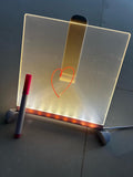 3D LED writing pad illuminated with a heart drawing and a pink marker beside it
