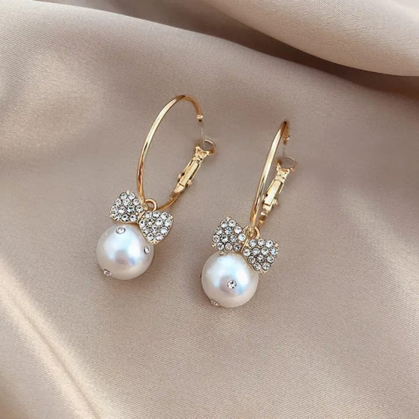 Elegant bow knot earrings featuring a pearl and sparkling rhinestone bow accents
