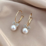Elegant bow knot earrings featuring a pearl and sparkling rhinestone bow accents