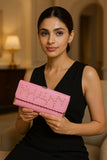 Elegant pink studded clutch held by a model in a stylish black dress for chic fashion lovers
