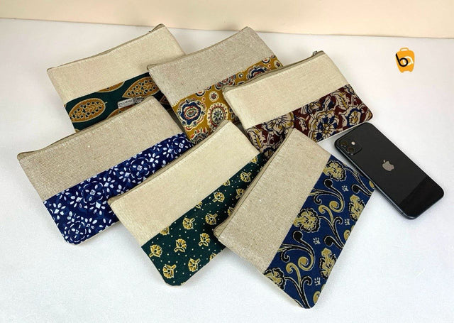 Variety of ethnic cotton canvas clutch bags in different patterns with a smartphone for size reference