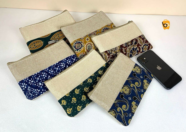 Variety of ethnic cotton canvas clutch bags in different patterns with a smartphone for size reference