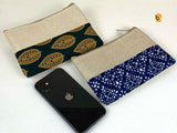 Ethnic cotton canvas clutch bags in blue and green patterns with a phone for scale