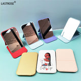 Colorful foldable makeup mirror set displayed on a blue surface for easy viewing and portability
