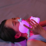 Kawaii reindeer touch lamp for kids glowing softly in a child's hands while relaxing in bed