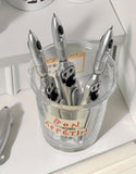 Collection of Dropdash retractable writing pens in a clear glass container with a label