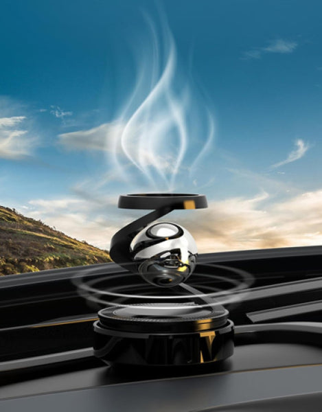 Solar levitating car air freshener with a sleek design and floating aroma emblem in a scenic backdrop