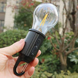 Hand holding a USB emergency bulb light designed for portable use and outdoor lighting